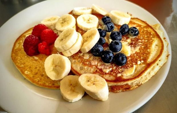 Hot cakes con plátano, frambuesas y arándanos