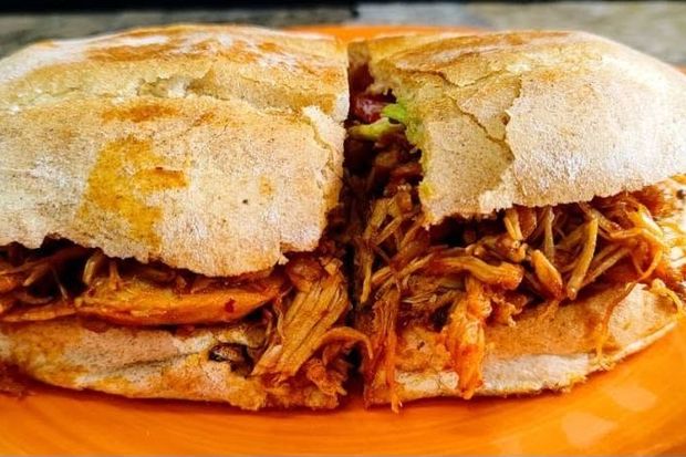 Torta de cochinita servida en plato naranja
